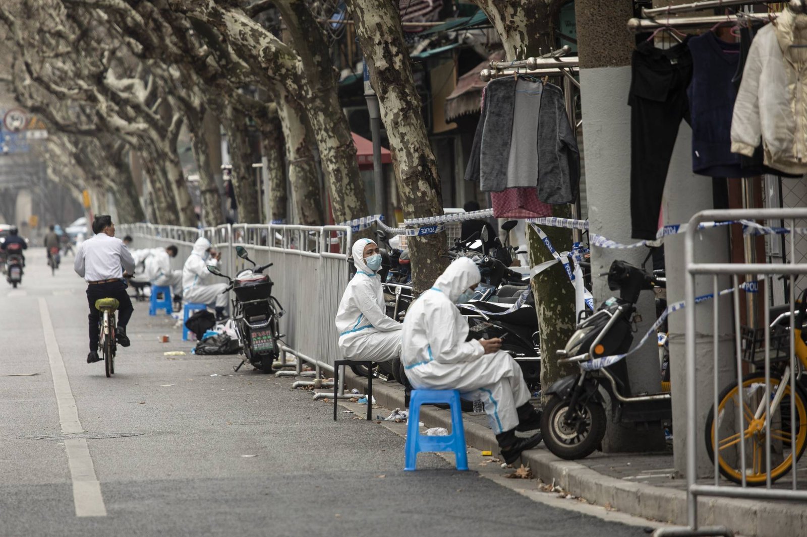 Quarantine workers on a street in a neighborhood that was just put under lockdown for rising COVID-19 cases in Shanghai, China, March 15, 2022. Many Asian-Pacific countries are dismantling thickets of coronavirus pandemic rules at bewildering speeds, with one notable exception: mainland China, which is still rolling out lockdowns. (Qilai Shen/The New York Times)